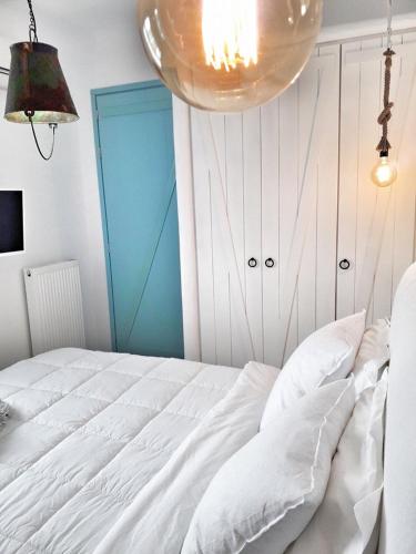 a bedroom with a white bed and a blue door at Villa Arion in Batsi