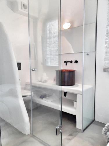 a bathroom with a glass shower with a sink at Villa Arion in Batsi