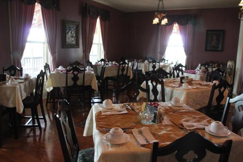 a dining room table filled with plates and cups at Lynwood Inn in Baddeck