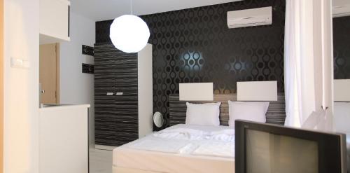a bedroom with a bed with a tv and a wall at Hotel Rainbow 3 Resort Club in Sunny Beach