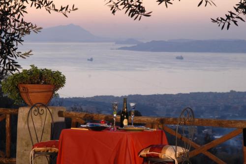 a table with a red table cloth and bottles of wine at La Dimora le Fumarole Rooms in Ercolano