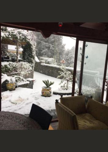 a living room with a snow covered yard with a couch at La Dimora le Fumarole Rooms in Ercolano