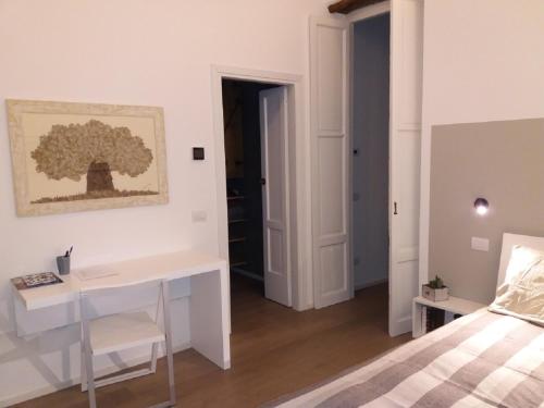 a white bedroom with a desk and a bed at Le Quinte del Duomo in Como