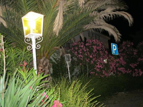 a street light with a parking sign and flowers at Casa Morgado in Almeida