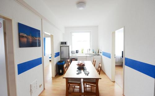 a dining room with a table and a kitchen at Basement Küchgarten in Hamburg