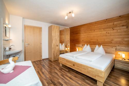 um quarto com uma cama grande e uma parede de madeira em Appartements Jeitner em Wenns