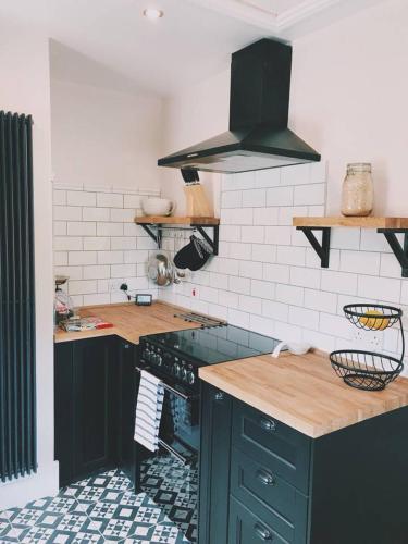 a kitchen with a black stove and a counter at No.03 Cottage in Strathkinness