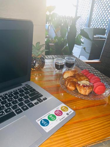 a laptop computer sitting on a table with a plate of food at Spat Beach in Bat Yam