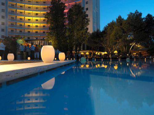 a swimming pool in a city at night at Hotel President in Silvi Marina