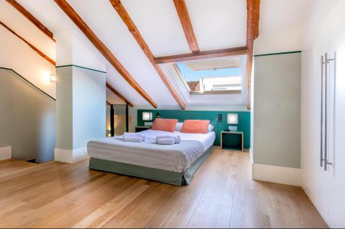 um quarto com uma cama e uma clarabóia em Slow Suites Chueca em Madrid