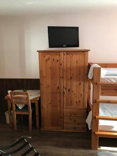 Schlafzimmer mit einem TV auf einem Holzschrank in der Unterkunft Hotel Guntia Boardinghouse in Günzburg