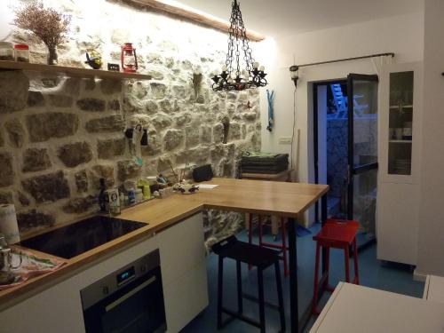 a kitchen with a counter and a stone wall at Apartment Old Town Design in Rab