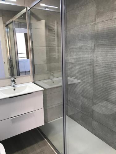 a bathroom with a glass shower and a sink at Apartament L'Alba in Tossa de Mar