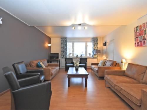 Una sala de estar con sofás y una mesa. en Apartment in Ober Waroldern mit Sauna, en Oberwaroldern