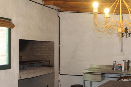a dining room with a fireplace and a chandelier at Quinta El Monte in Tandil