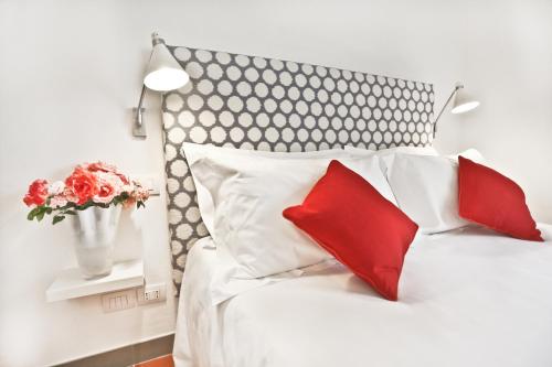 a bedroom with a white bed with red pillows at Poggio Baronti B&B in Bagno a Ripoli