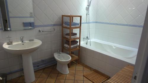 une salle de bain avec un lavabo, des toilettes et une baignoire dans l'établissement spacieux logement face à la Cité Médievale, à Carcassonne