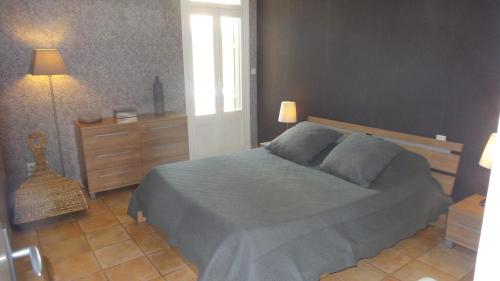 - une chambre avec un lit, une commode et une lampe dans l'établissement spacieux logement face à la Cité Médievale, à Carcassonne