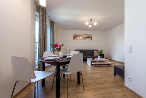 a dining room and living room with a table and chairs at P&O Apartments Zawiszy in Warsaw