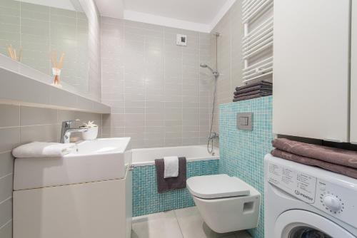 La salle de bains est pourvue d'un lavabo et d'un lave-linge. dans l'établissement P&O Apartments Zawiszy, à Varsovie