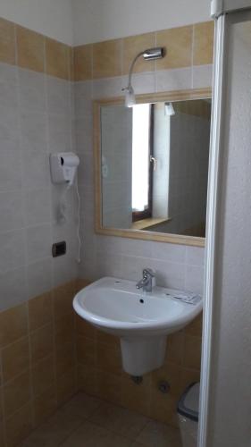 La salle de bains est pourvue d'un lavabo et d'un miroir. dans l'établissement Laghetto ai Portici, à Pastrengo