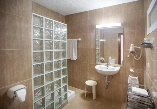 baño con lavabo y pared de cristal en Apartamentos La Jabega, en Fuengirola