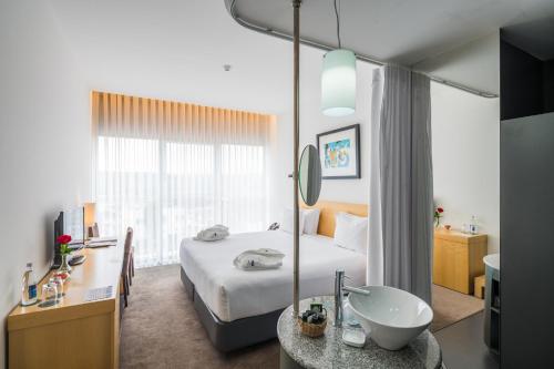 a hotel room with a bed and a sink at Boticas Hotel Art & SPA in Boticas
