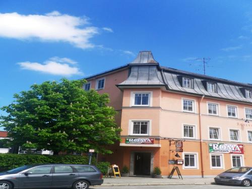 a building with a pointed roof on a street at Hotel Rosenheimer Hof in Traunstein