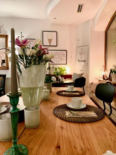 a room with a wooden table with a vase of flowers at Sommers Hotel Altes Posteck in Reichenbach im Vogtland