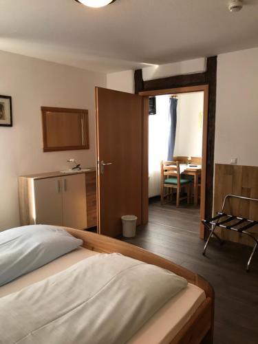 ギュンツブルクにあるHotel Guntia Boardinghouseのベッドルーム1室(ベッド1台付)、テーブル付きのベッドルーム1室が備わります。