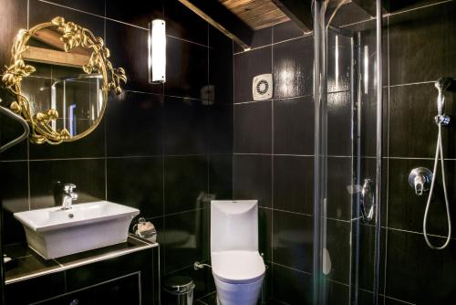 a bathroom with a sink and a toilet and a mirror at Leandros Hotel in Nea Roda