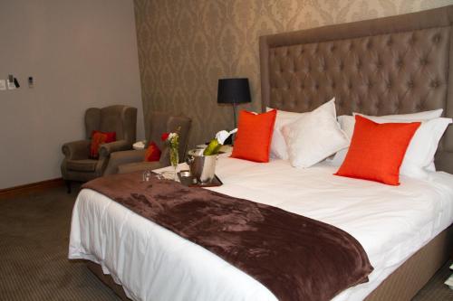 a bedroom with a large bed with red and white pillows at Classique Grace Boutique Hotel in Johannesburg