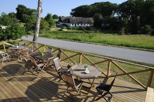 a deck with a table and chairs and a road at STF Baskemölla Hostel in Simrishamn