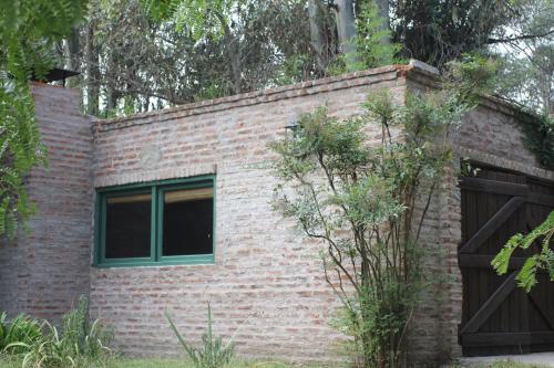 a brick building with a window and a garage at Quinta El Monte in Tandil