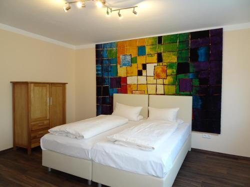 1 dormitorio con 1 cama con una pintura en la pared en Hotel & Weinstube Restaurant Filling, en Frankenthal