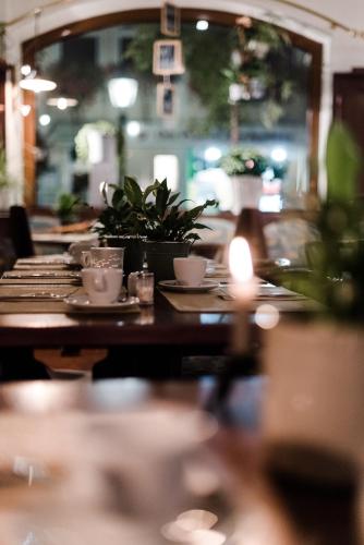 a table with plates and cups and plants on it at Sommers Hotel Altes Posteck in Reichenbach im Vogtland