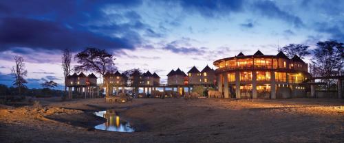 un grande edificio con molte finestre al tramonto di Salt Lick Safari Lodge a Tsavo