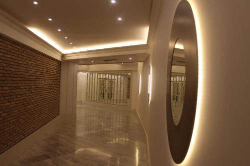 a hallway with a mirror and a brick wall at Hotel Reyes Ziries in Albolote