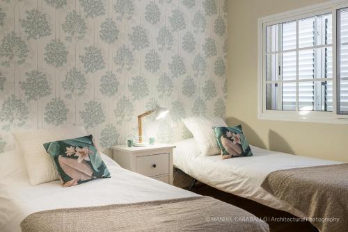 マスパロマスにあるDuplex luxury Meloneras Hillのベッドルーム1室(ベッド2台、窓付)