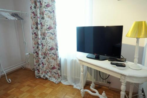 TV en una mesa blanca en una habitación en MA-LIVING Villa Elenor en Mainz