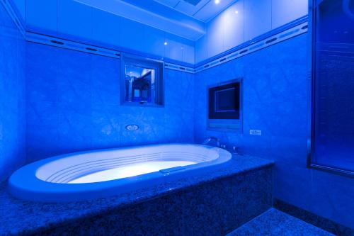 a bathroom with a large tub with blue lighting at HOTEL D-WAVE Shinjuku（Adult Only) in Tokyo