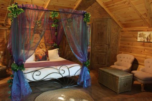 a bedroom with a bed with a canopy and a chair at Domaine De La Boulaie in Treize-Vents