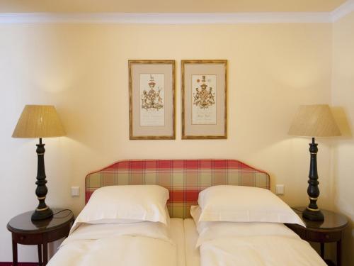 two beds in a room with two lamps at Hotel City House in Hamburg