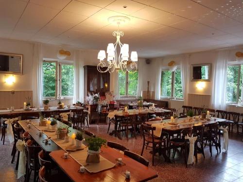 a dining room with tables and chairs and a chandelier at Bungalows Zur Alten Fähre in Werder