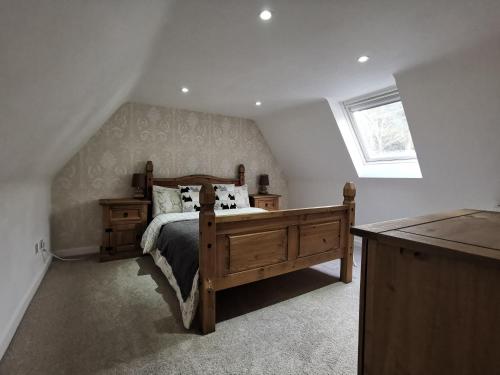 ルスにあるNorth Cottageのベッドルーム1室(木製ベッド1台、窓付)