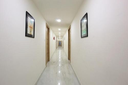 a long hallway with two pictures on the walls at Hotel Anjali Park in Kottayam