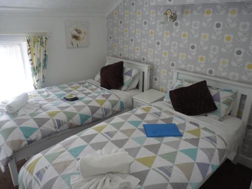 two beds sitting next to each other in a bedroom at The Berkswell in Blackpool
