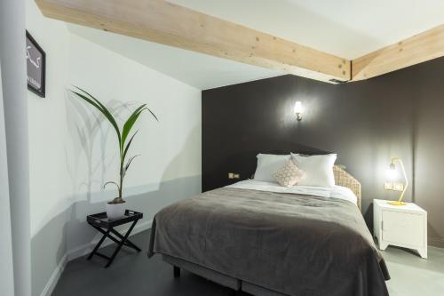a bedroom with a bed and a black wall at L'Abeille - Boutique Apartments in Nice