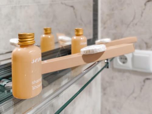a shelf with three bottles on it in a bathroom at WESTAY Hotel in Tbilisi City
