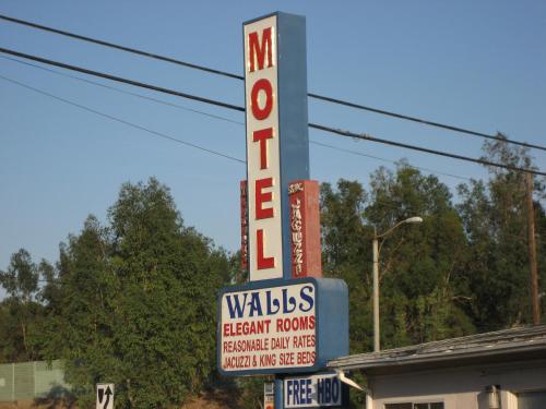 una señal para una habitación de beneficencia con un cartel de motel en Walls Motel Long Beach, en Long Beach